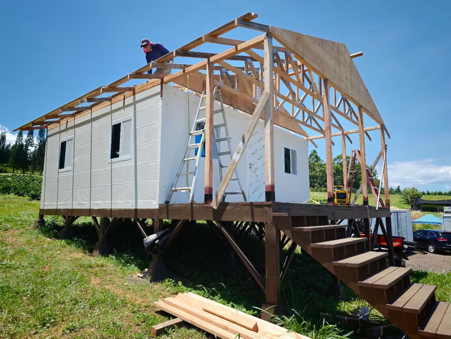 Container house with timber roof framing under construction, a raised deck and access stairs